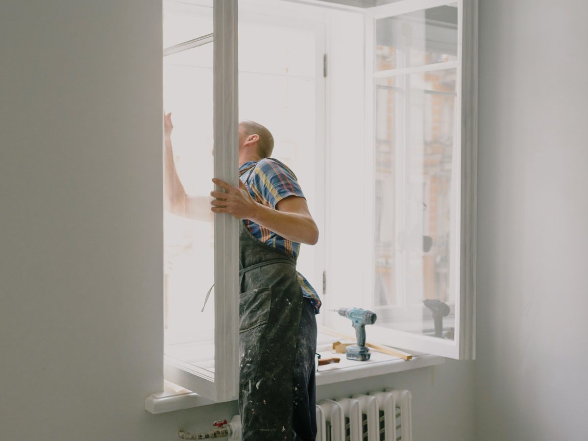 Profissional instalando janela em apartamento em reforma
